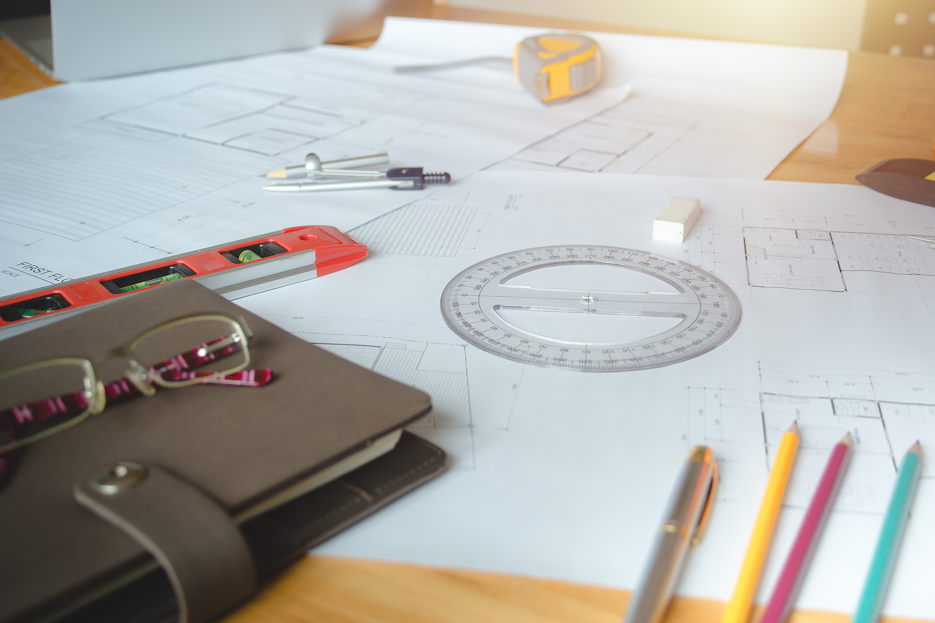 Plany architektoniczne na dobudówkę domu. Projekt architektoniczny, plany, ołówek i dzielnik kompas na drewnianym biurku. Tło budowlane. Narzędzia inżynieryjne